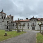 Fachada principal y torres de la iglesia del Monasterio de San Salvador de Cornellana en Salas, Asturias, vista desde la plaza exterior.