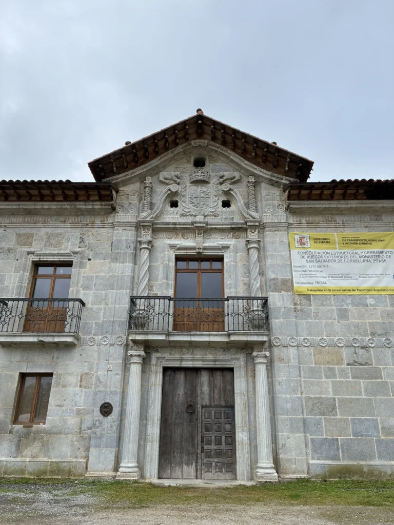 Portada barroca del Monasterio de San Salvador de Cornellana con columnas salomónicas y escudo heráldico en Salas, Asturias.