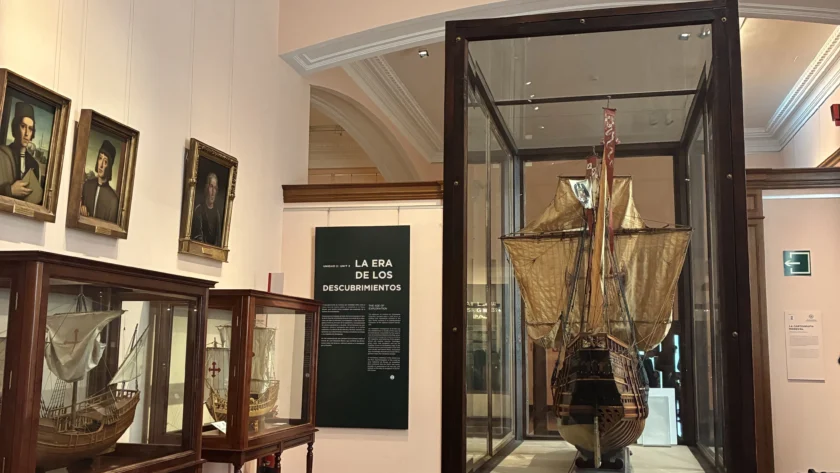 Sala "La Era de los Descubrimientos" en el Museo Naval de Madrid con modelos de barcos históricos en vitrinas de madera y retratos de navegantes.