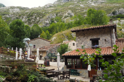 Arquitectura tradicional de piedra en Bulnes de Abajo con bares y terrazas bajo las montañas de Picos de Europa.