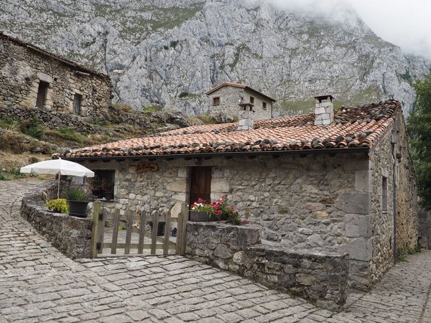 Casas de piedra tradicionales con tejados de teja en el pueblo de Bulnes, Asturias, bajo las montañas de Picos de Europa.