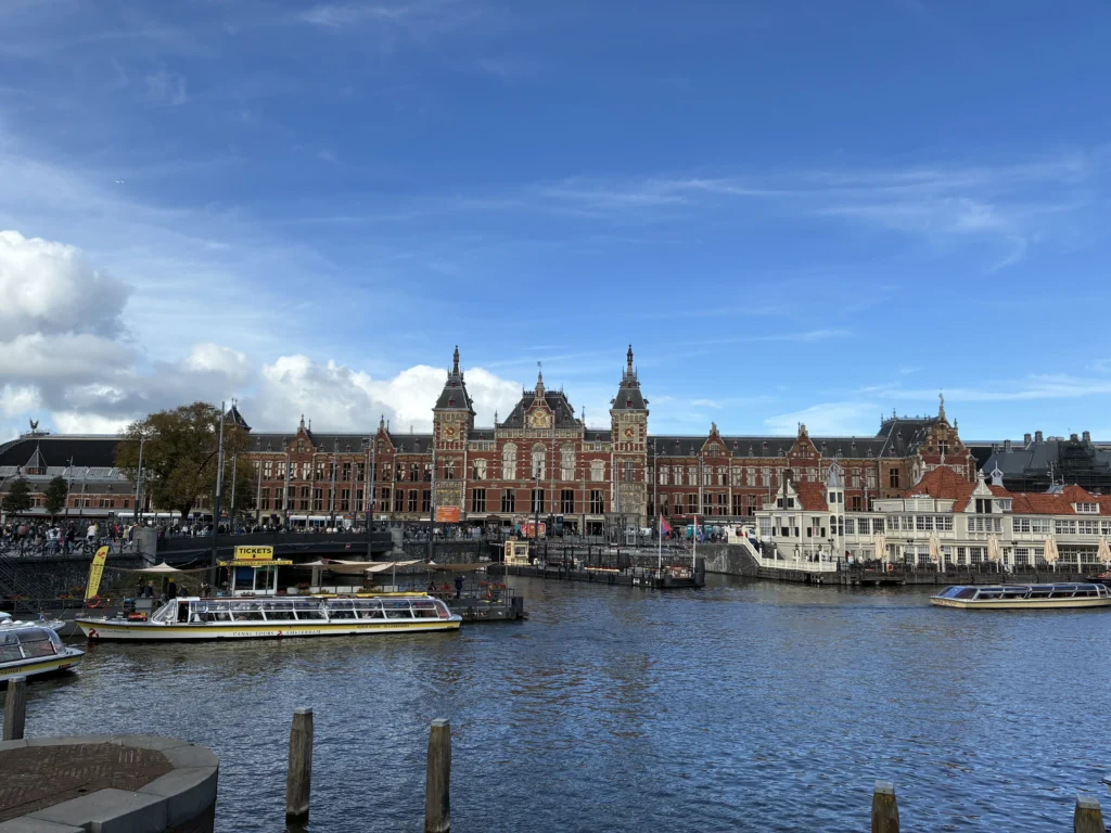 La fachada monumental de la Estación Central de Ámsterdam vista desde la dársena del canal Damrak.