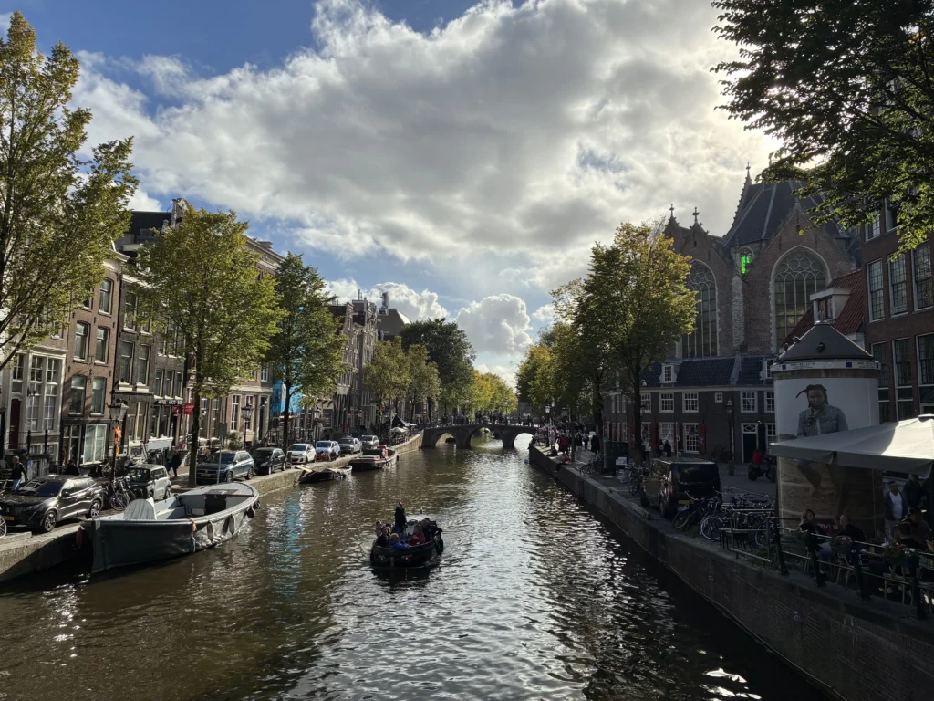 arco navegando por el canal Oudezijds Voorburgwal en el Barrio Rojo junto a la histórica iglesia gótica Oude Kerk.