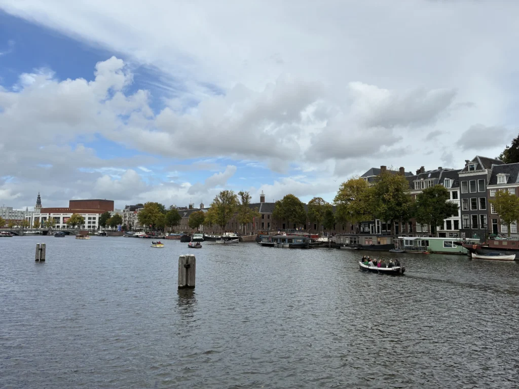 Amplia vista panorámica del río Amstel en Ámsterdam desde el puente de madera Magere Brug hacia el teatro de la ópera.